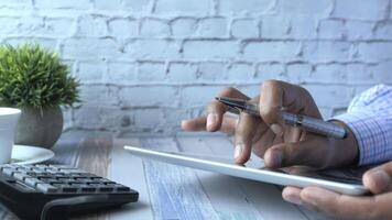 Man using tablet and calculator at desk video