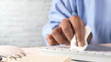 A person using a wipe to clean a keyboard video