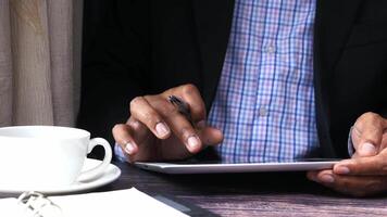 A man in a suit is using a tablet computer video