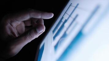 A person is pointing at a graph on a tablet video