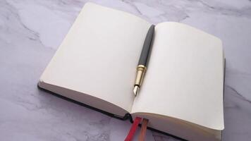 An open notebook with a pen on top video
