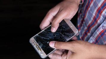 A person holding a broken cell phone with a broken screen video
