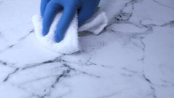 A person in blue gloves cleaning a marble countertop video