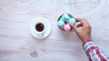 A person holding a cup of coffee and a bowl of colorful marshmallows video