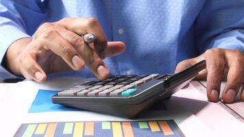 A person is using a calculator on a desk video