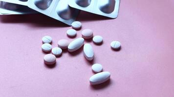 Pills and tablets on a pink surface video