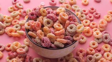 Colorful cereal in a cup on a pink background video