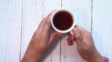A person holding a cup of tea on a white table video