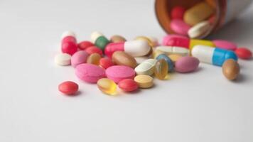 Pills and capsules spilling out of a bottle video