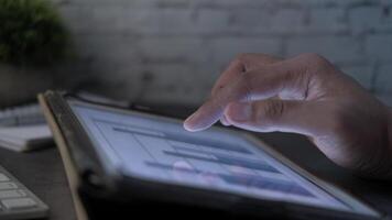 en person är använder sig av en läsplatta dator med en Graf på den video