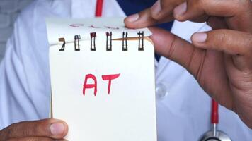 A doctor holding a notepad with the word tat written on it video