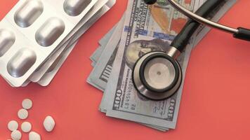 A stethoscope and money on a pink surface video