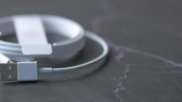 A white apple lightning cable is connected to a computer video