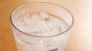 A glass of ice water with ice cubes in it video