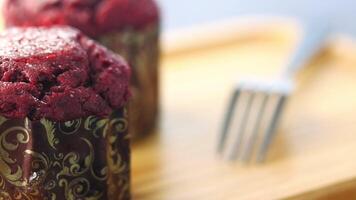 A red muffin with a fork sitting on top of a wooden tray video