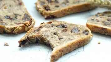 Slices of bread with nuts and raisins on a white surface video