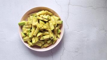 A bowl of sliced cucumbers on a white surface video