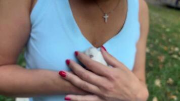 An adorable and fluffy white hamster is lovingly cradled in a womans hand while outdoors video
