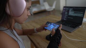 A Focused Gamer Actively Engaged in Mobile Gaming While Utilizing a Coding Setup at Home video