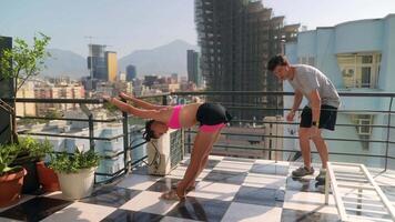 Engaging in a dynamic yoga practice atop a rooftop with a stunning city view around you video