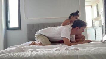 A couple is relaxing together on their bed while using a laptop and enjoying each others company video
