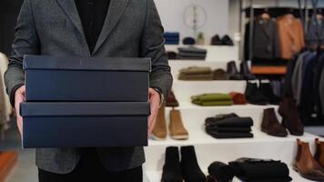 A man with shoe boxes in clothing store video
