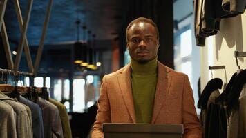Handsome black man walking with shoe boxes in clothing store. A man buying shoes in the store video