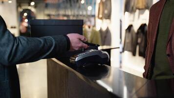 Man In Clothing Store Making Contactless Payment With App On Mobile Phone, Close Up video