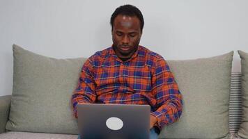 Young african american man software developer programming codes while working from home video