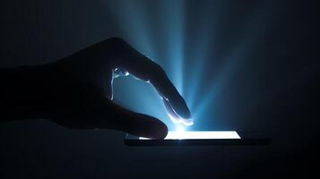 A hand is holding a phone in the dark. The light from the screen is illuminating the hand and the phone. The background is dark. photo