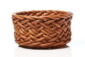 An empty wicker basket sits on a white table. The basket is made of light brown wicker and has a round shape. The basket is empty and has a shadow on the table. photo