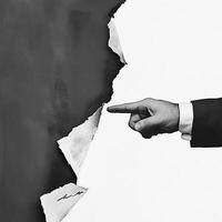 A business concept image shows a hand in a suit pointing at torn paper, symbolizing breakthrough and innovation. The minimalist, abstract design emphasizes creativity, disruption, and modern corporate photo