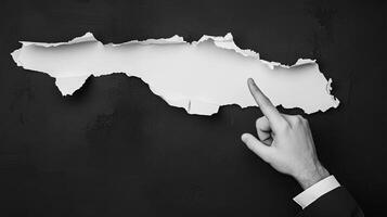 A business concept image shows a hand in a suit pointing at torn paper, symbolizing breakthrough and innovation. The minimalist, abstract design emphasizes creativity, disruption, and modern corporate photo