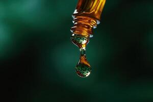 A delicate amber glass bottle with oil glistens as droplets form at its tip, captured in tranquil surroundings. The soft light accentuates the rich colors, creating a serene atmosphere. photo