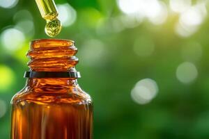 The captivating amber bottle stands alone, droplets of oil poised on a pipette, catching the soft sunlight. Surrounded by lush greenery, it evokes a sense of tranquility and purity. photo