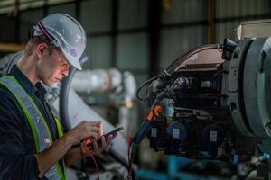 male engineer workers maintenance automatic robotic arm machine in a factory. worker checking and repairing automatic robot hand machine. technician worker check for repair factory machine. photo