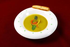 Creamy Butternut Squash Vegetable Soup with Herbs and bread served in bowl isolated on red background side view of arabic food photo