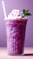 Purple granita in a tall glass with straws on a purple background. Summer drinks concept. photo
