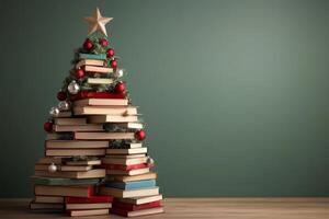 Stack of books arranged like a Christmas tree, topped with a star and ornaments photo