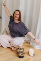 A happy woman after a breathing and singing bowl practice. photo