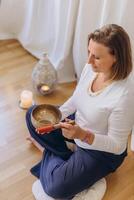 Young woman playing on a singing tibetian bowl.Relaxation and meditation.close-up of a singing bowl photo