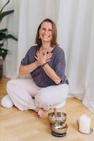 A happy woman after a breathing and singing bowl practice. photo