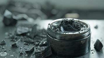 activated charcoal face wash container with charcoal pieces on a wooden table photo