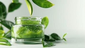 organic green tea face mask in a jar, surrounded by green tea leaves on a clean white surface photo
