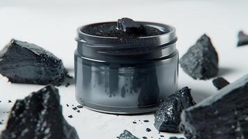 charcoal face lotion in jar with activated charcoal displayed on white background photo