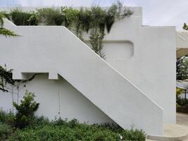 A white house with a flower-filled balcony in a garden on a sunny summer day photo