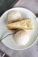 View from above of a tasty piece of cake and ice cream, on a plate with a fork photo