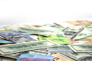 A close up image of a pile of US dollar and euro banknotes scattered on a white surface photo