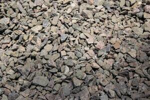 A close-up photograph of a pile of gray crushed stone gravel photo
