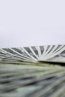 A close-up shot of several US dollar bills arranged in a fan shape, with a white background photo